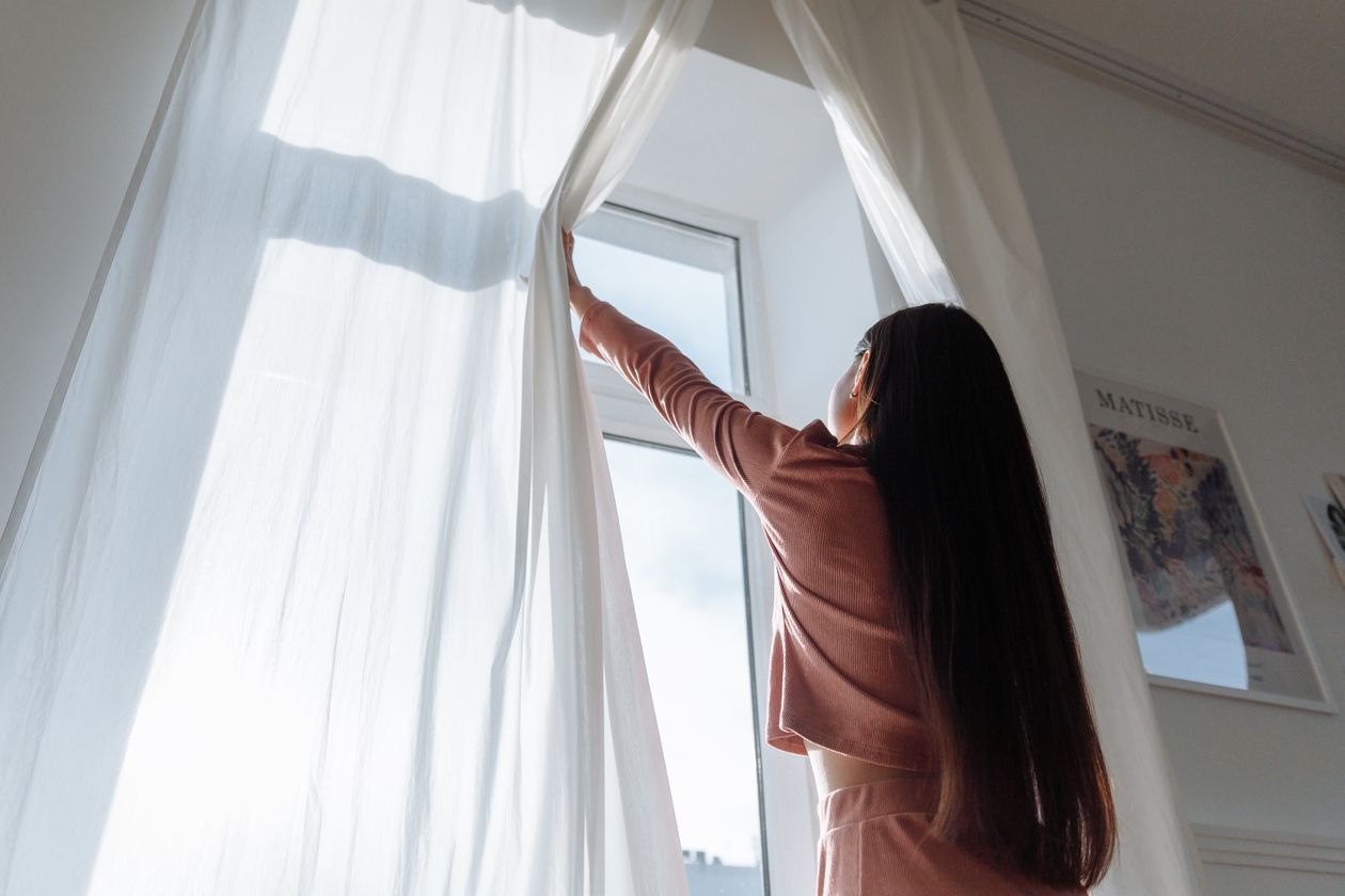 Rideau clair devant une fenêtre fermée pour bloquer la chaleur du soleil
