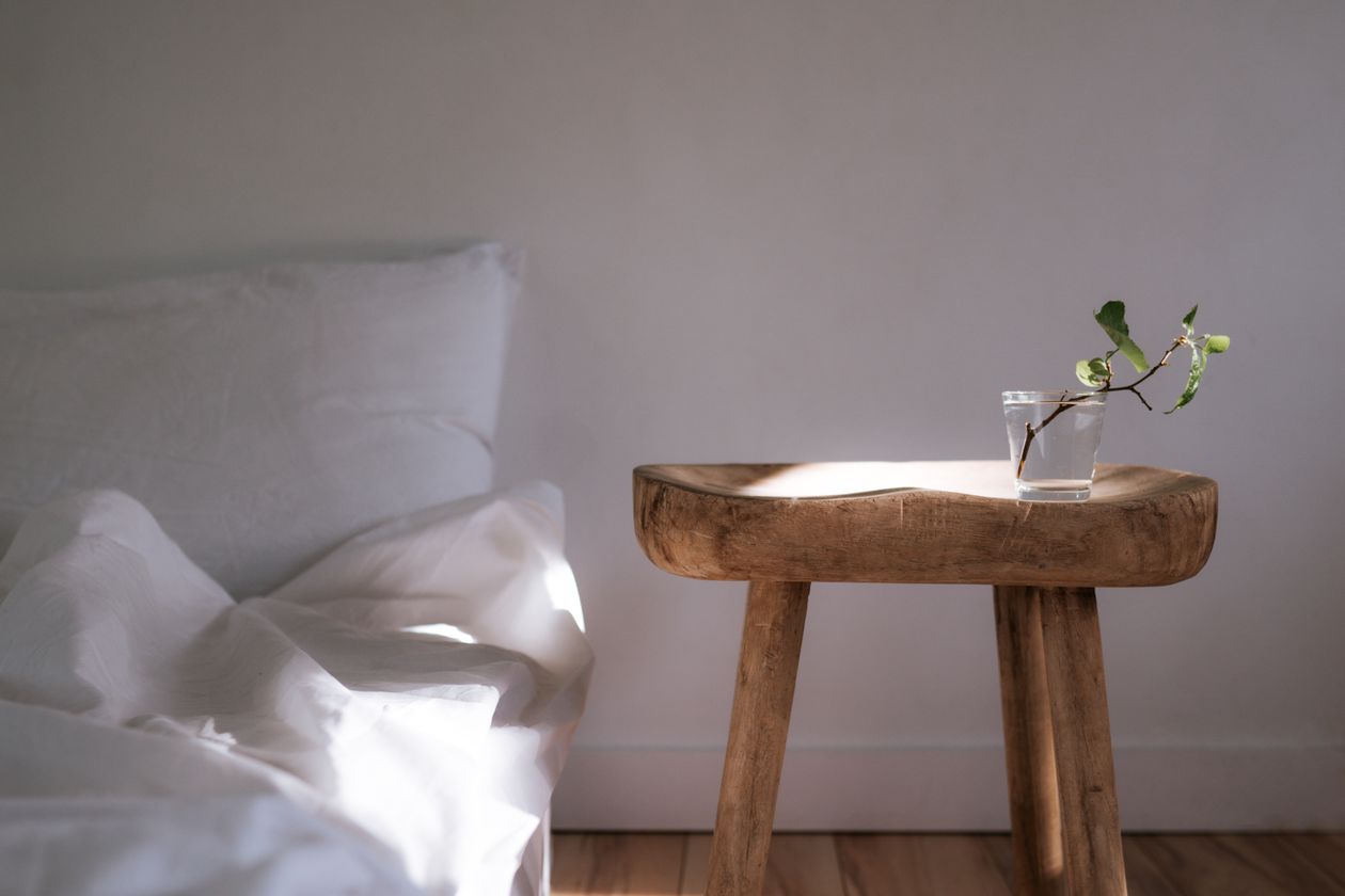 Verre d'eau posé sur une table de nuit en bois