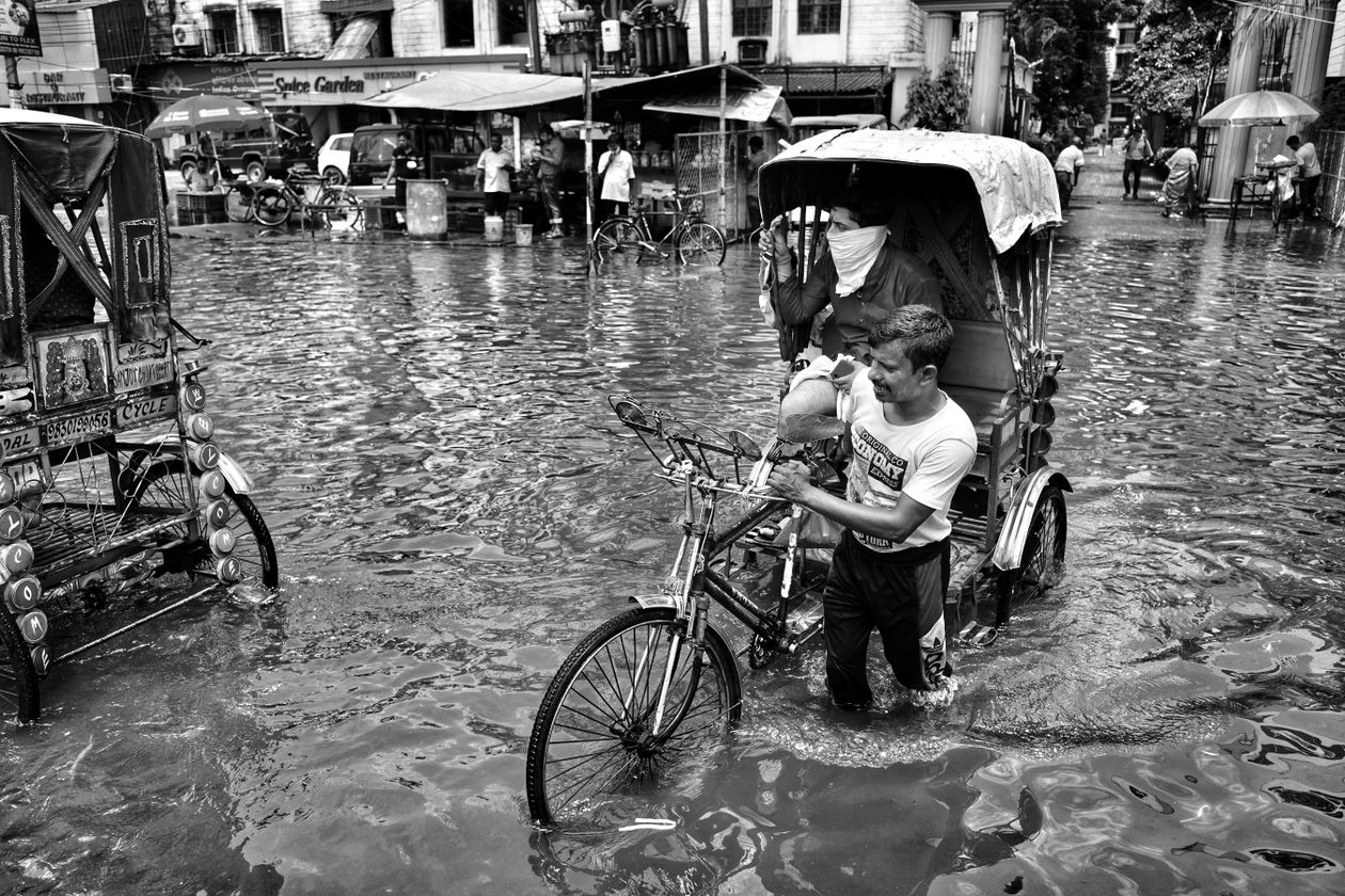 Véhicules et habitants dans une rue inondée en ville
