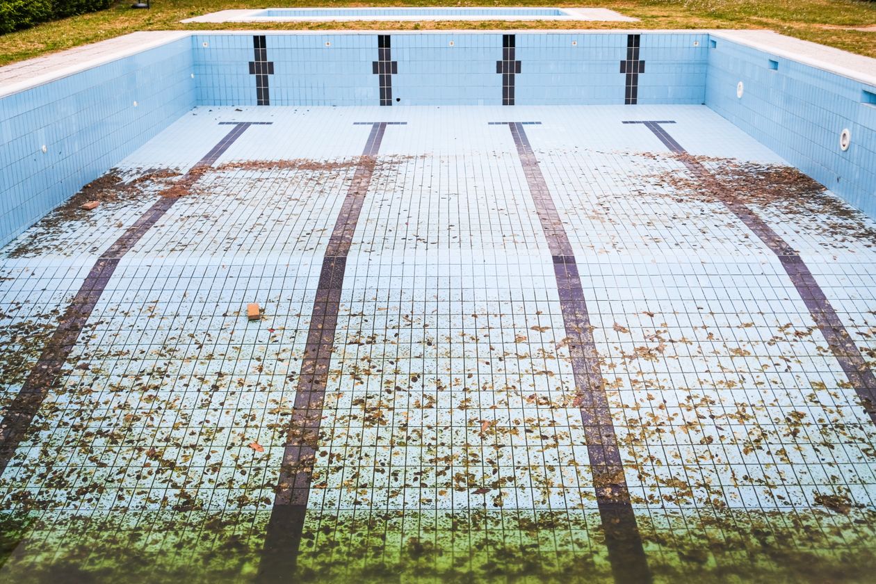 Piscine vidée et recouverte de feuilles en période d'hivernage