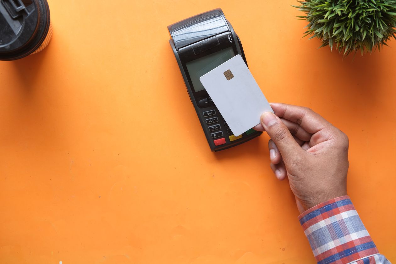 Personne effectuant un paiement sans contact avec une carte bancaire sur un terminal électronique