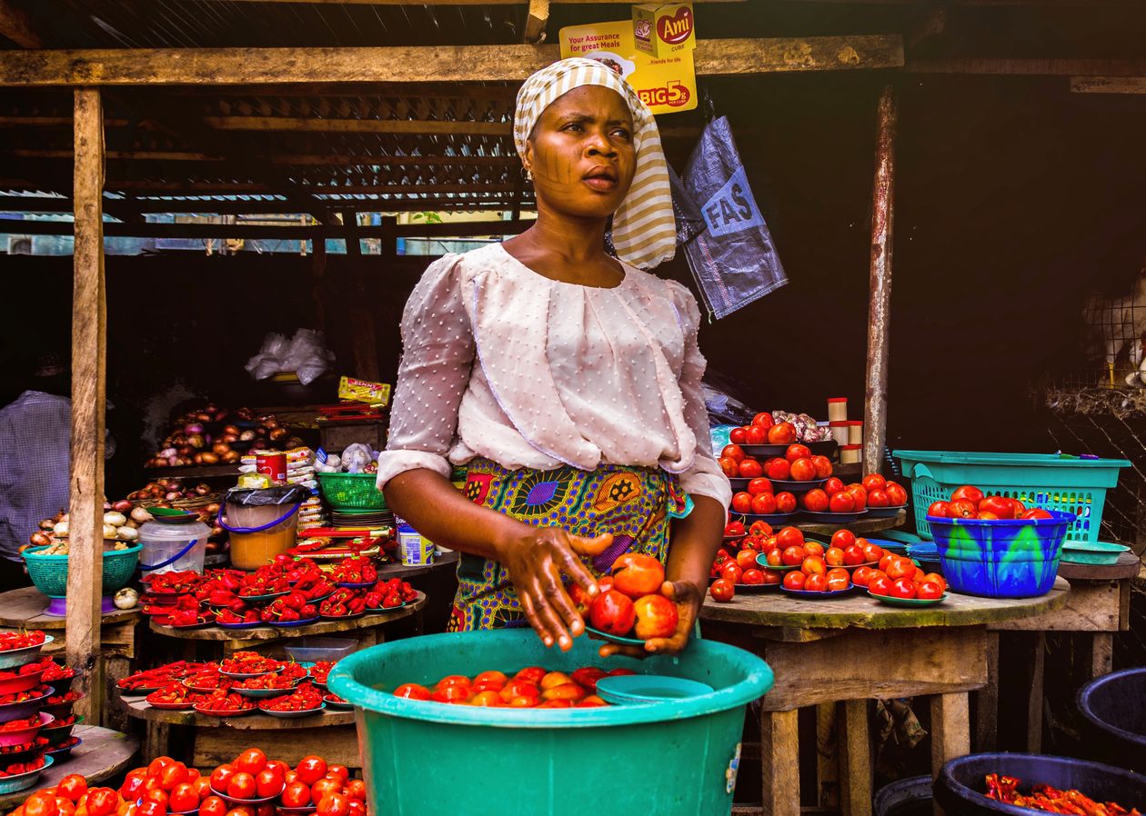 Vendeuse sur un marché présentant des tomates fraîches