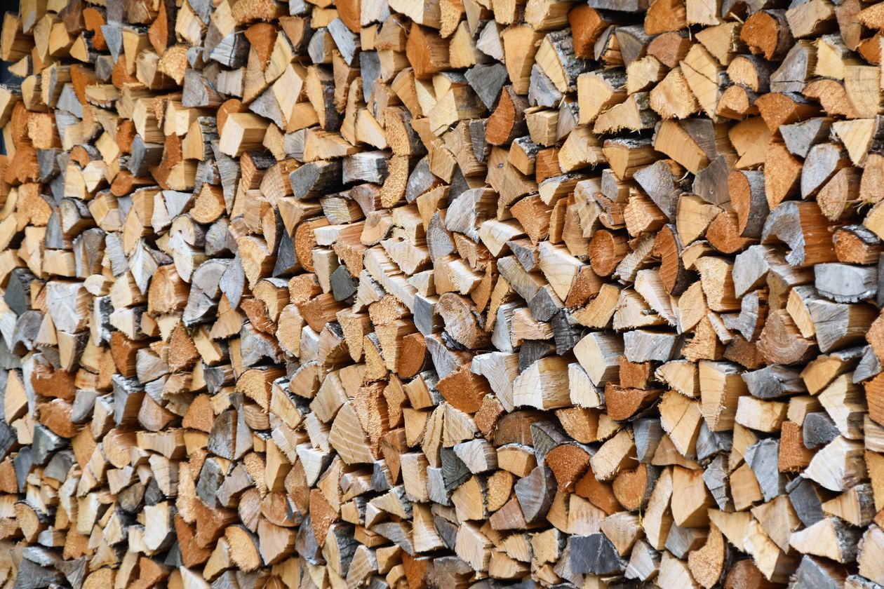 Bûches de bois empilées pour l'hiver, rappel de l'importance d'un conduit de cheminée bien entretenu